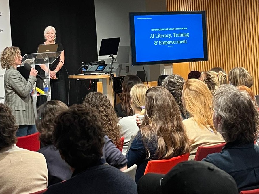 Brooke Gallagher speaking from a lectern at Nationale Opera & Ballet, leading an AI literacy session for staff.